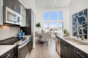 an open kitchen and dining room with a view of a living room